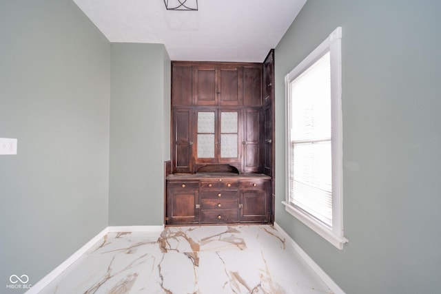 interior space featuring marble finish floor and baseboards