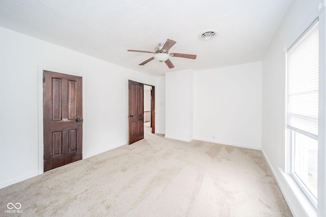 unfurnished bedroom featuring visible vents, ceiling fan, light carpet, and baseboards