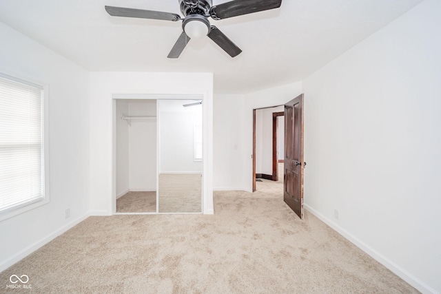 unfurnished bedroom with carpet floors, a closet, baseboards, and a ceiling fan