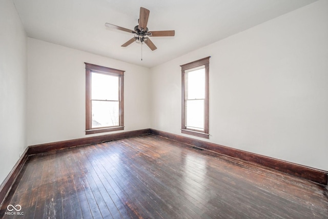 empty room with a wealth of natural light, baseboards, and hardwood / wood-style floors