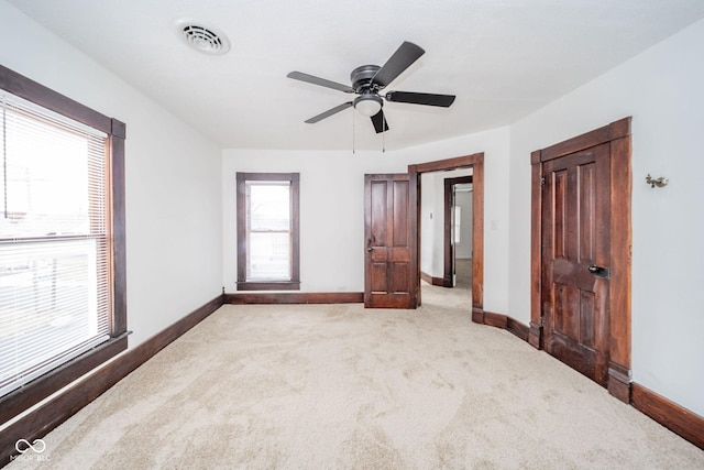 unfurnished bedroom featuring carpet floors, visible vents, baseboards, and a ceiling fan