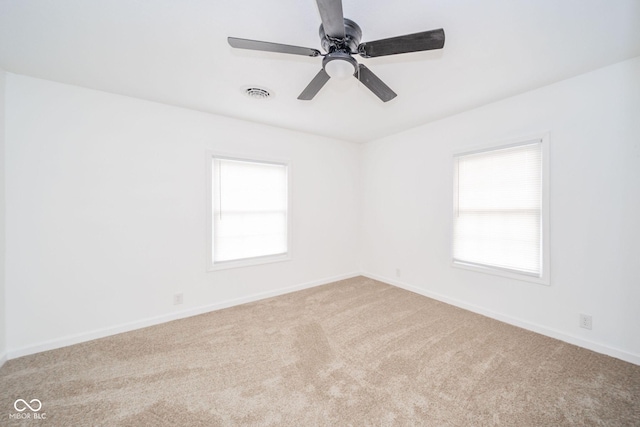 spare room with carpet, visible vents, plenty of natural light, and baseboards