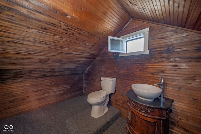 half bath featuring wood ceiling, vaulted ceiling, vanity, and toilet