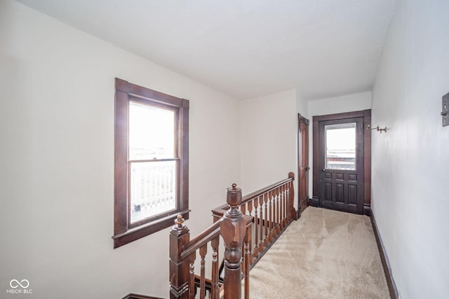 carpeted entryway featuring baseboards