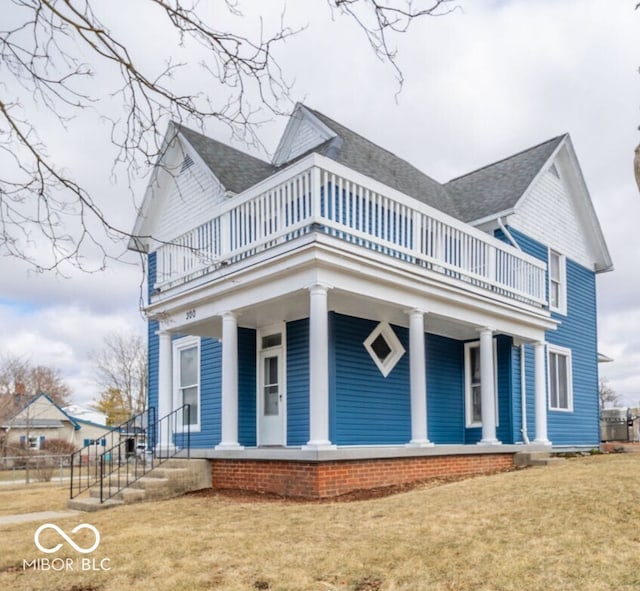 view of front of property with a balcony, a front lawn, and a porch