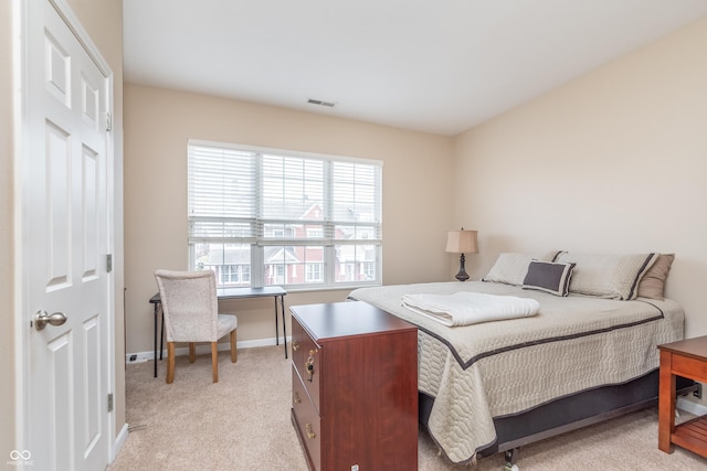 bedroom featuring visible vents, light carpet, and baseboards