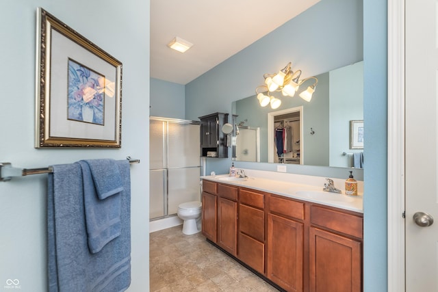 full bath featuring double vanity, a shower stall, toilet, and a sink