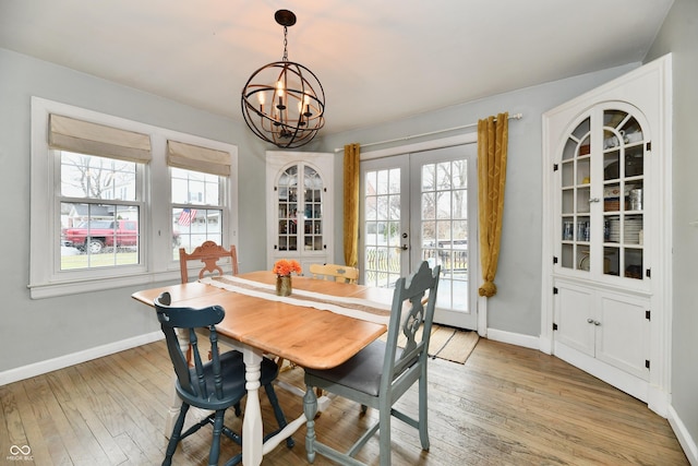 dining room featuring french doors, light wood-type flooring, and baseboards