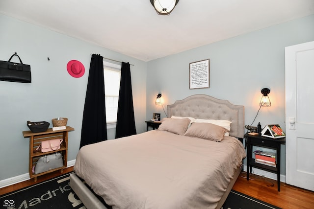 bedroom featuring baseboards and wood finished floors