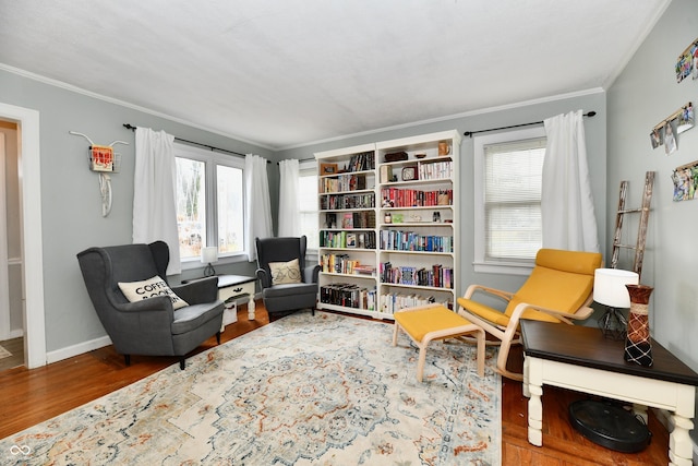 living area with ornamental molding, baseboards, and wood finished floors