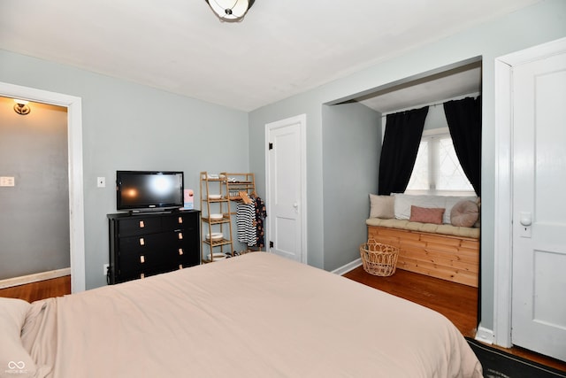 bedroom featuring wood finished floors and baseboards