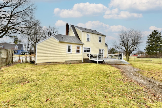 rear view of property with a fenced backyard and a yard