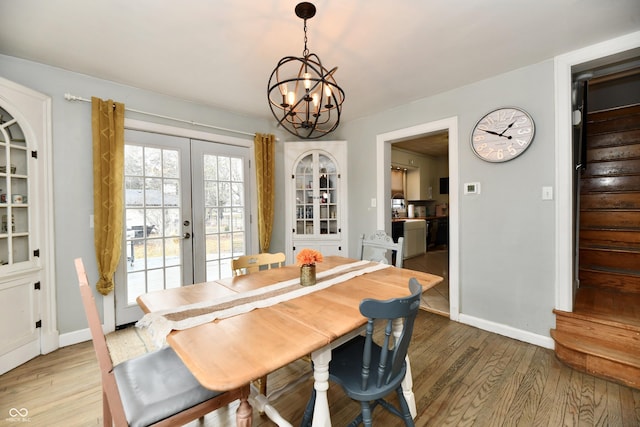 dining space with a chandelier, baseboards, light wood-style floors, french doors, and stairway