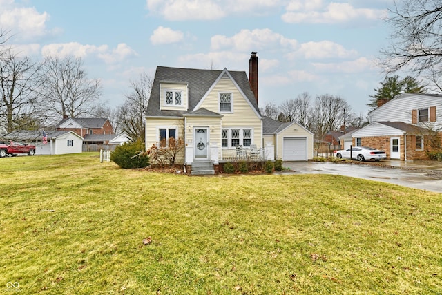 view of front of property featuring concrete driveway, a chimney, a detached garage, an outbuilding, and a front lawn