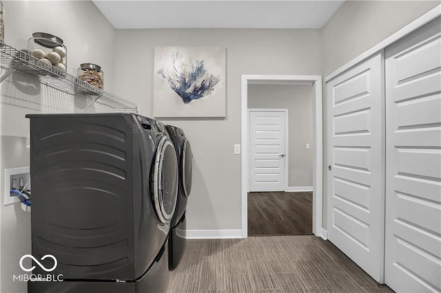 clothes washing area with laundry area, baseboards, separate washer and dryer, and wood finished floors