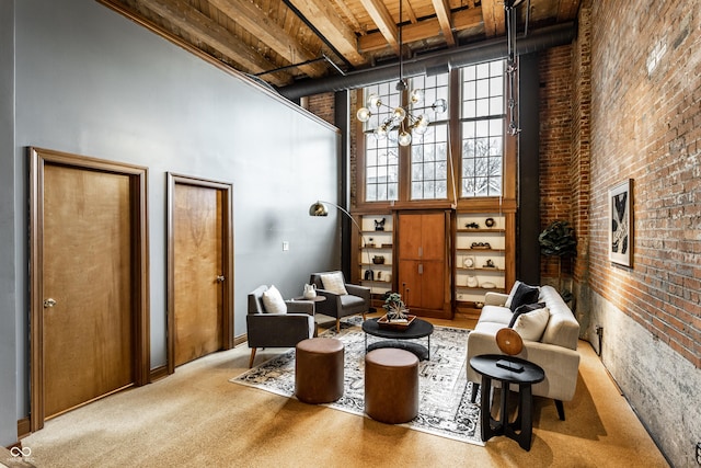 living area with carpet, brick wall, a high ceiling, and a notable chandelier