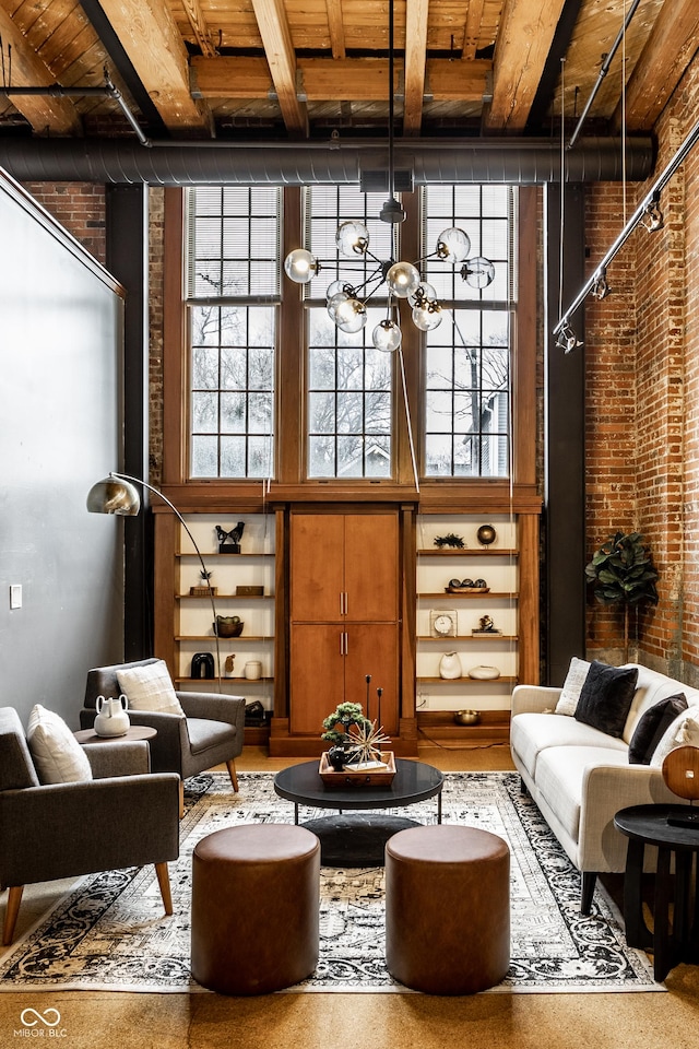 living area featuring a high ceiling, brick wall, and an inviting chandelier