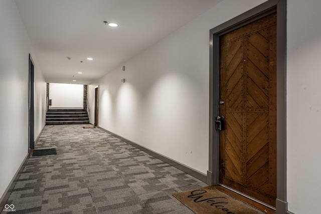 hallway featuring recessed lighting, carpet flooring, baseboards, and stairs