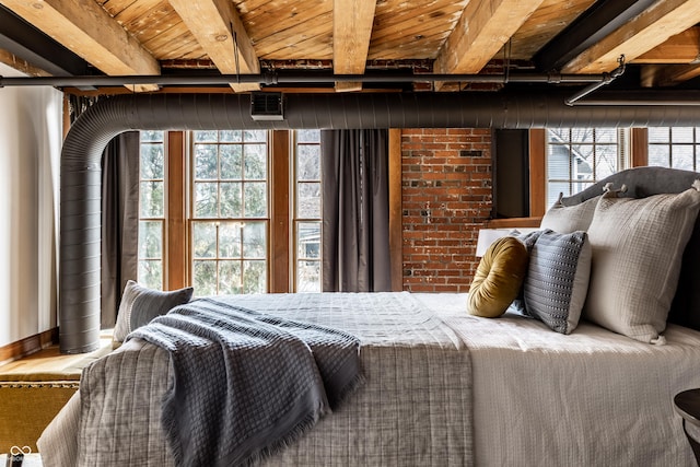 bedroom with brick wall, multiple windows, visible vents, and beamed ceiling