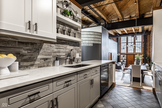 kitchen with open shelves, backsplash, a sink, beamed ceiling, and dishwashing machine