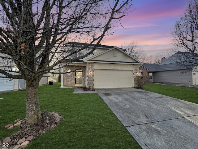 view of front of house featuring driveway, brick siding, an attached garage, and a front yard