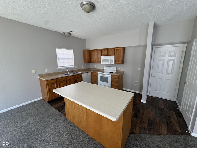 kitchen with white appliances, brown cabinetry, light countertops, and a sink