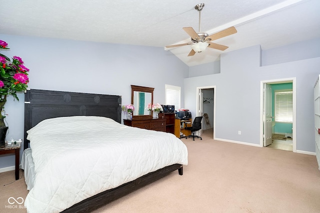 bedroom with a spacious closet, light carpet, vaulted ceiling, ceiling fan, and baseboards