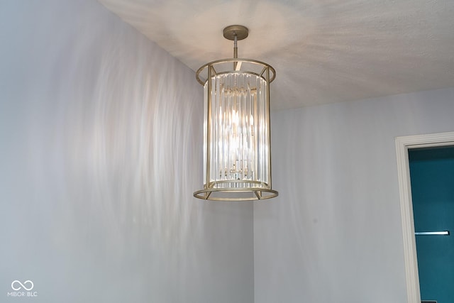 room details featuring a textured ceiling and a notable chandelier