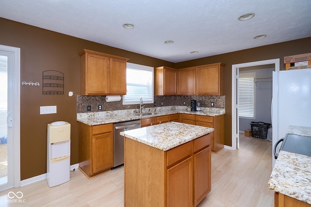 kitchen featuring a sink, decorative backsplash, dishwasher, and freestanding refrigerator