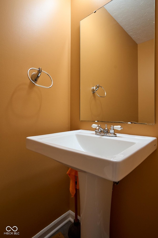 bathroom featuring a textured ceiling and baseboards