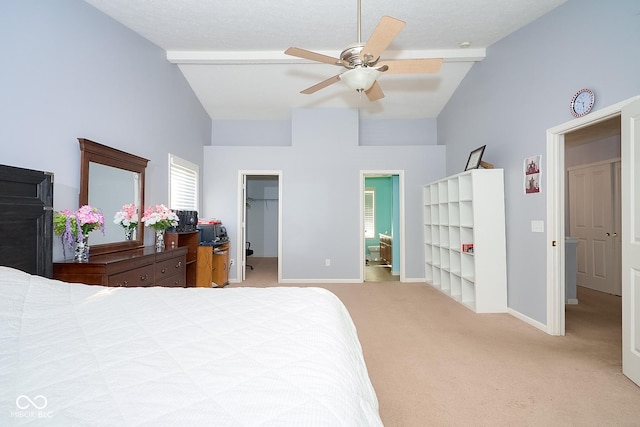 bedroom featuring light carpet, high vaulted ceiling, a walk in closet, and baseboards