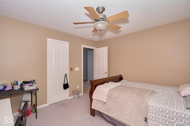 bedroom with light carpet, a ceiling fan, baseboards, and a textured ceiling