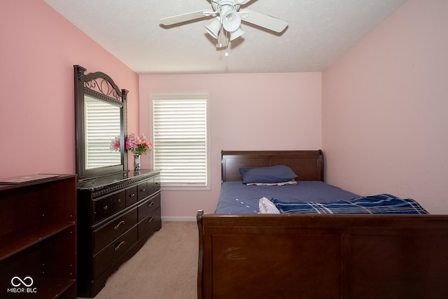 bedroom featuring light carpet, a textured ceiling, a ceiling fan, and baseboards