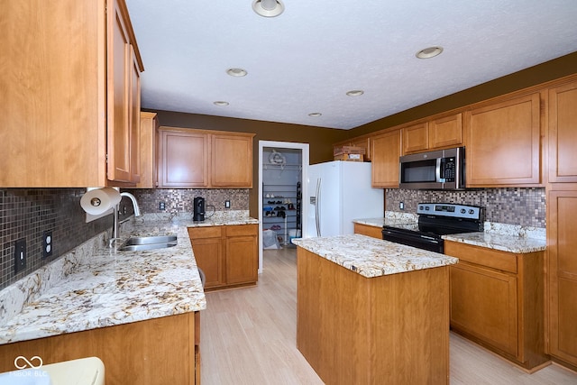 kitchen featuring stainless steel appliances, a kitchen island, a sink, and brown cabinetry