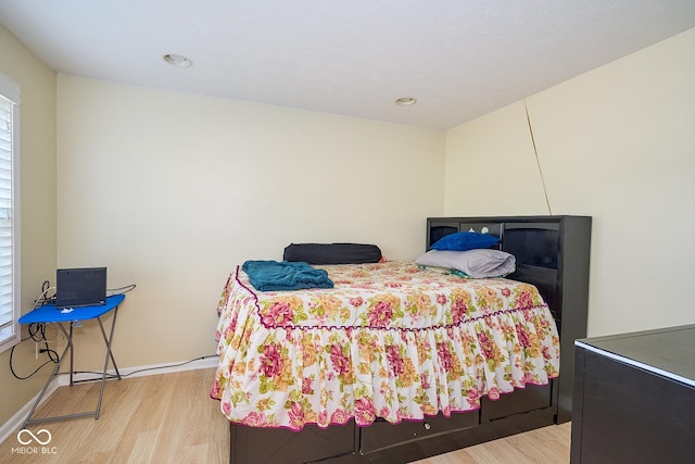 bedroom with wood finished floors and baseboards