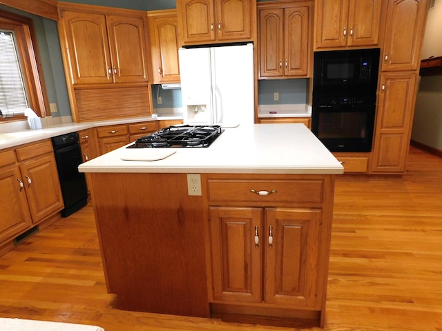1229 E Tara Rd, Greensburg, IN 47240 - kitchen featuring black appliances, light wood finished floors, light countertops, and a kitchen island