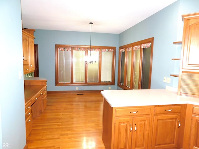 1229 E Tara Rd, Greensburg, IN 47240 - kitchen featuring light wood-style flooring, a peninsula, light countertops, and pendant lighting