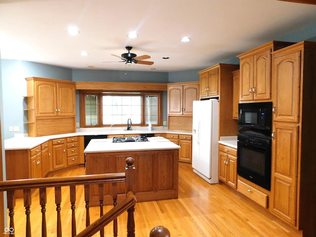 1229 E Tara Rd, Greensburg, IN 47240 - kitchen featuring black appliances, ceiling fan, light wood finished floors, light countertops, and a kitchen island