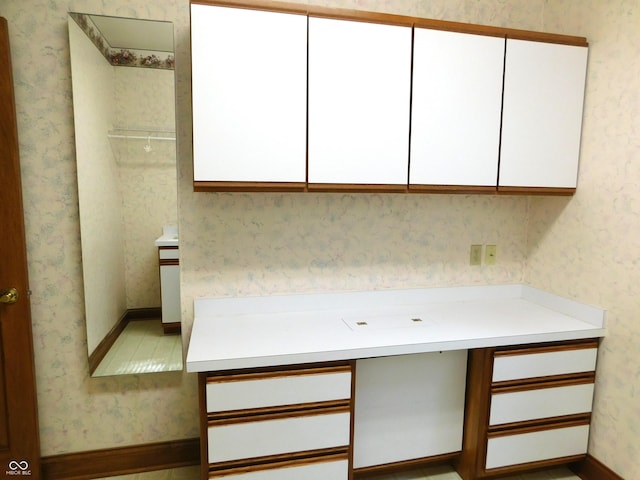 1229 E Tara Rd, Greensburg, IN 47240 - kitchen with white cabinetry, wallpapered walls, light countertops, and a desk