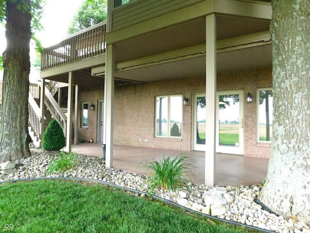 1229 E Tara Rd, Greensburg, IN 47240 - rear view of house featuring stairway, a patio area, a deck, and brick siding