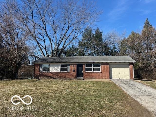 single story home featuring a garage, concrete driveway, brick siding, and a front yard