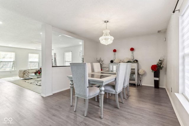 dining room featuring an inviting chandelier, baseboards, and wood finished floors