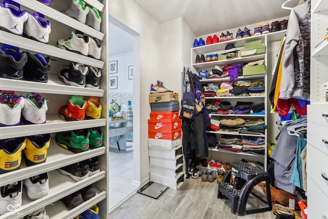 walk in closet with wood finished floors