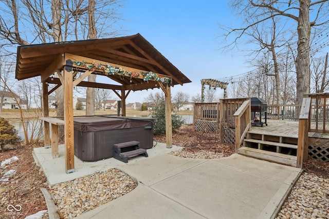 view of patio with a hot tub, a wooden deck, and a gazebo