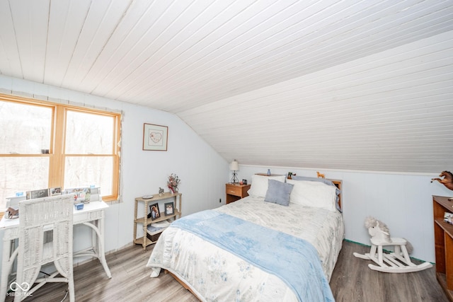 bedroom with lofted ceiling and wood finished floors