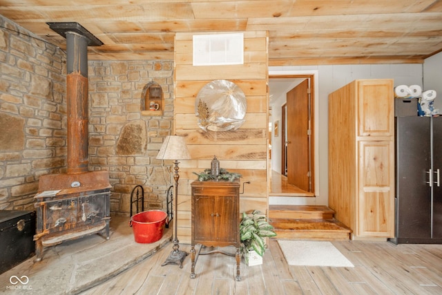 interior space with a wood stove, visible vents, and wood finished floors