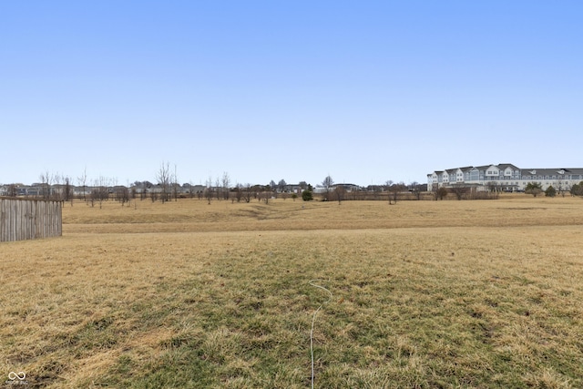 view of yard featuring a rural view and fence