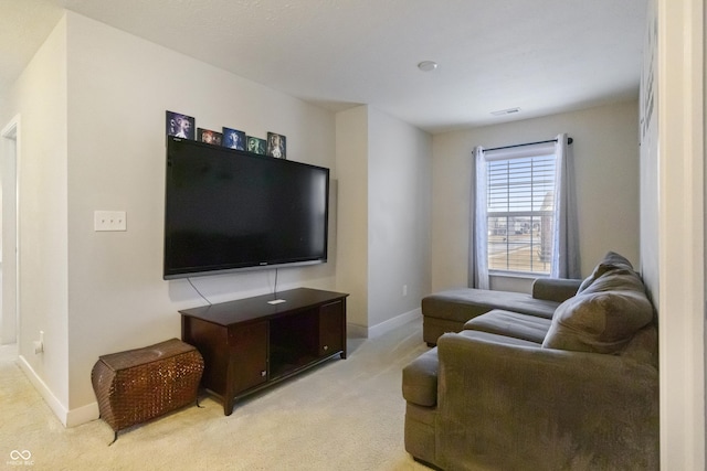 living area featuring baseboards and light colored carpet