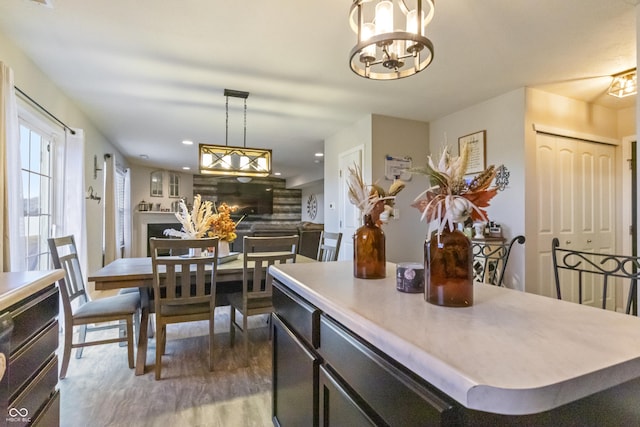 kitchen with recessed lighting, a fireplace, wood finished floors, light countertops, and pendant lighting