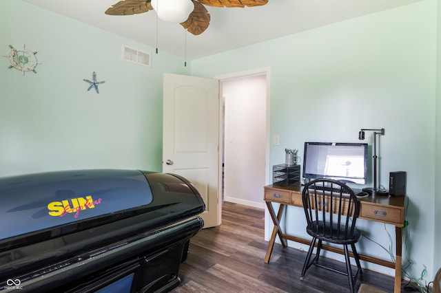 office area with ceiling fan, dark wood-type flooring, visible vents, and baseboards